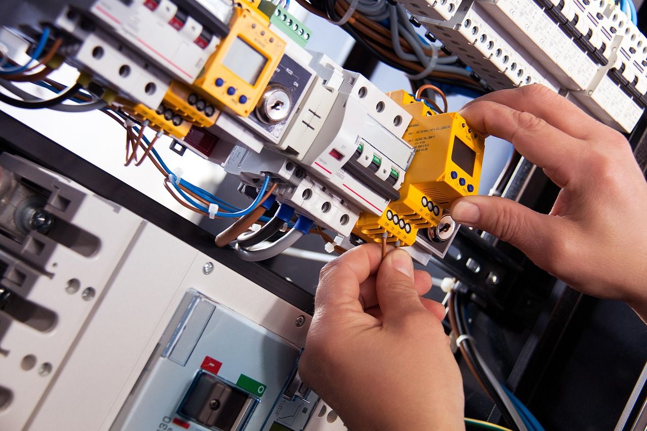 Electrician fitting a device in a distribution board